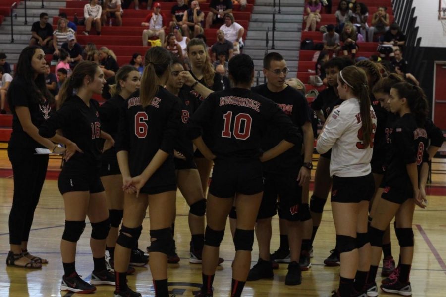 Coach Jacovinich is having a team huddle with the girls from the varsity level. The girls played North Brunswick at home and won two sets to one. Photo courtesy of Keith Du.