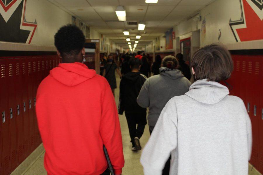 Students walk down hallway.