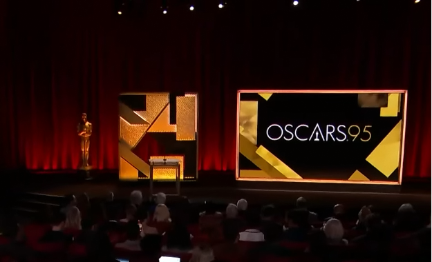 A still photo from a video, overlooking a crowd waiting for the presentation to start, featuring the decorated stage where the 95th Oscars Nominations are being held.
