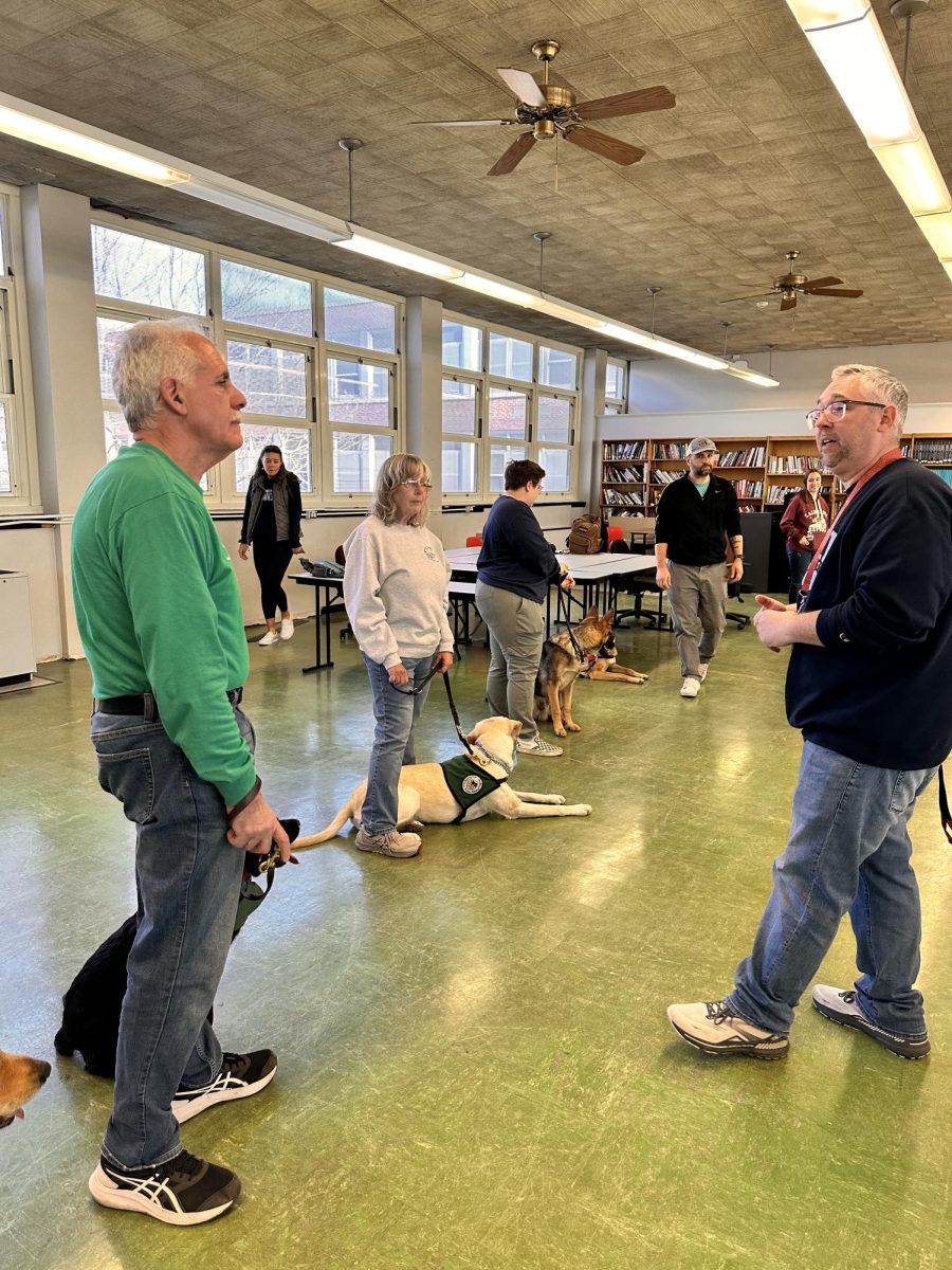 Mr. Switek, The SOS Club advisor, speaks with a therapy dog volunteer.