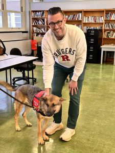 Mr. Nowicki poses with a therapy dog at the visit to WHS.